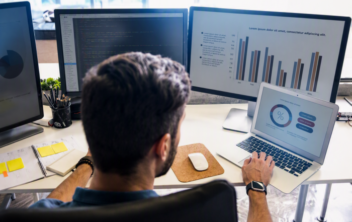 IT professional monitoring business performance dashboards and network analytics on multiple screens as part of managed IT services from Duplicator Sales & Service in Kentucky.